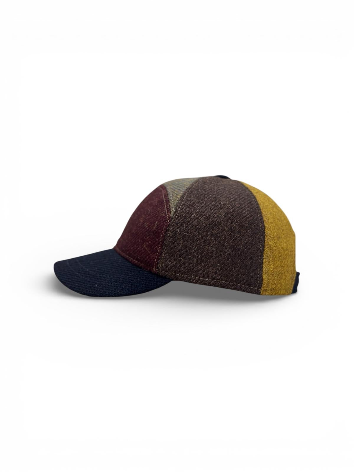 Modello baseball mezza luna con diversi colori di tessuto shetland rigato con comodo regolatore posteriore per una vestibilita’ più confortevole
