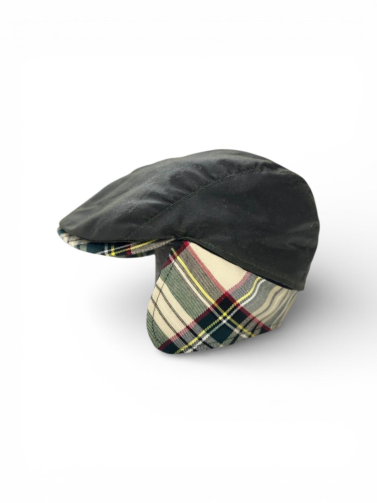 Modello Liverpool con coprinuca in tessuto impermeabile originale Barbour inglese di colore verde. Con visiera e copriorecchie in tessuto lana. Interno del copri orecchie in calda microfibra nera